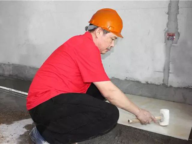 5鋪貼地磚時(shí)，磚的背面朝上批刮水泥油，并按箭頭所指方向統(tǒng)一鋪貼，用橡皮錘從中到邊，由重到輕敲實(shí).jpg